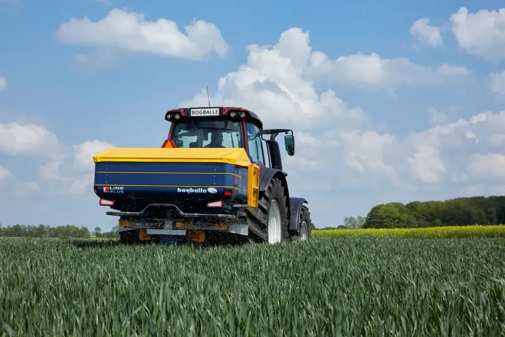 Vista trasera de la abonadora Bogballe L20W plus abonando un campo de cereal