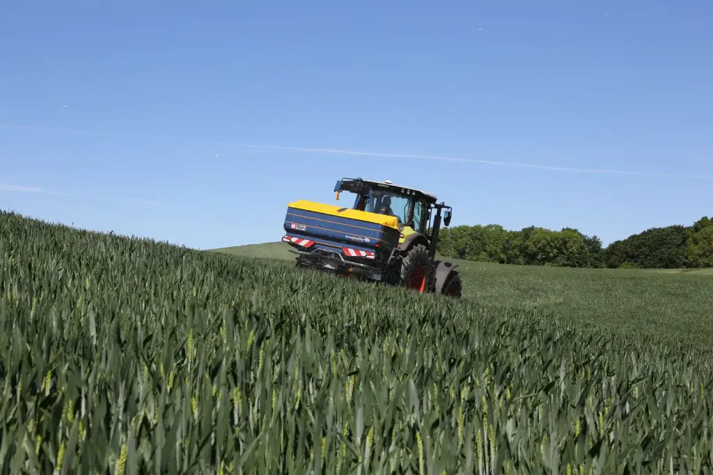 Abonadora Bogballe M35 base trabajando en un campo de cereal en ladera